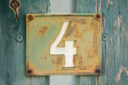 Old retro weathered cast iron plate with number 4 closeup