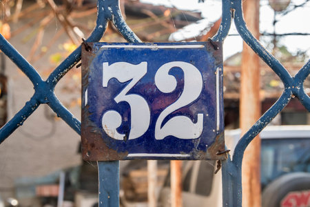 Weathered grunge square metal enameled plate of number of street address with number 32の写真素材