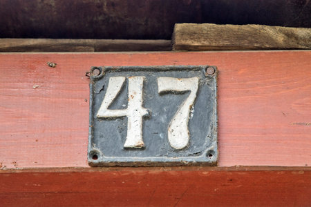 Old retro weathered cast iron plate with number 47 closeup