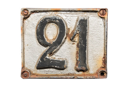 Old retro weathered cast iron plate with number 21 closeup isolated on white background