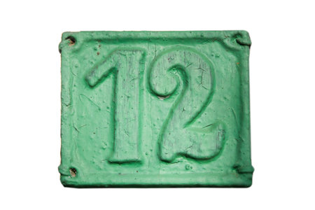 Old retro weathered cast iron plate with number 12 closeup isolated on white backgroundの写真素材