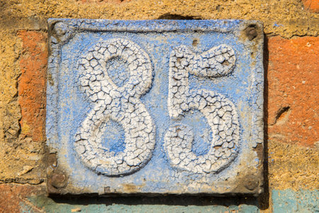 Old retro weathered cast iron plate with number 85の写真素材