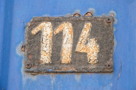 Old retro weathered cast iron plate with number 114の写真素材