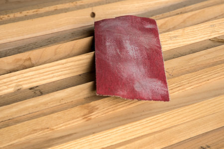 Piece of sandpaper on stacked pile of wooden slats closeupの写真素材