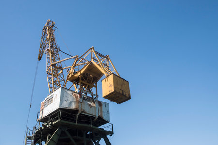 Crane against the blue sky, close-up. Industrial background. Port industrial cranes at river...
