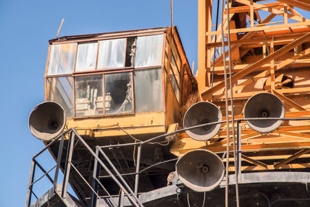 Construction site with crane and blue sky background, closeup of photo. Port industrial cranes at river unloading depot on clear sunny dayの写真素材