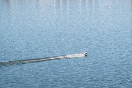 Speed boat floating on the water surface of the river. View from above.