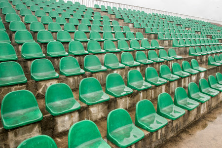 Empty green plastic seats in stadium, waiting for sports event or competitionの写真素材