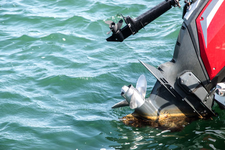 Outboard engine propeller on motorboat closeup on sea waters backgroundの写真素材