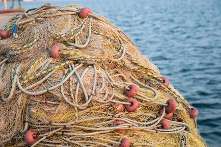 Vibrant fishing nets and buoys piled on a dock, ready for the sea, closeupの写真素材