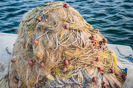 Vibrant fishing nets and buoys piled on a dock, ready for the sea, closeup