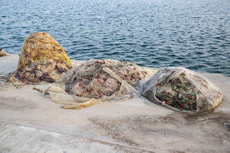 Vibrant fishing nets and buoys piled on a dock, ready for the sea, closeupの写真素材