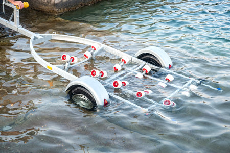 Boat trailer submerged in water, ready for launching or retrieving a vessel closeupの写真素材