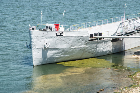Decommissioned river vessel serving as stationary pontoon between shore and moored passenger ship