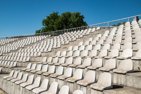 Rows of empty seats on the tribune of the stadium.