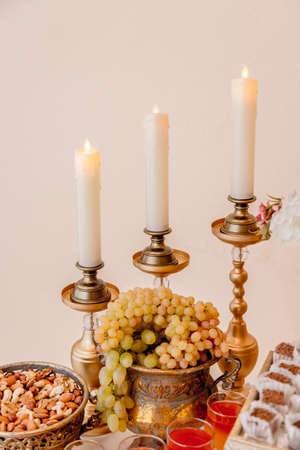 A part of wedding buffet table with candles and grape