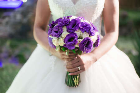 Bride holding her bouquet in the gardenの写真素材