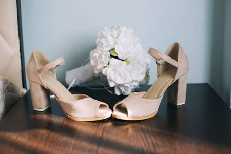 Wedding bridal shoes in bedroom with white bouquet behimdの写真素材