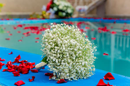 Wedding bucket at pool with natural rose petalsの写真素材