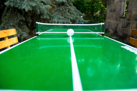 Table tennis game and a ball on green tennis boardの写真素材