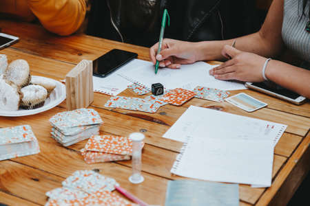Girls playing board games and writing something on paperの写真素材