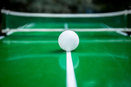 Table tennis ball with green background. Playing game outdoor.の写真素材