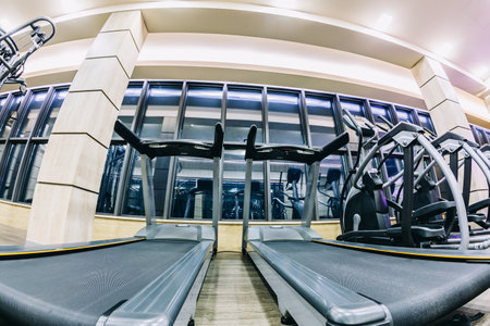 Professional treadmills in sport complex in front of windows