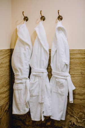 Three bathrobes hanging in spa roomの写真素材
