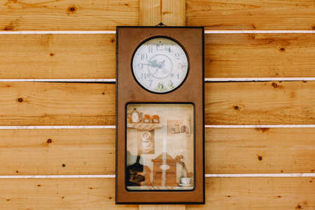 Creative antique wall clock hanging on wooden wall. Clock ornament for cafe and restaurant....