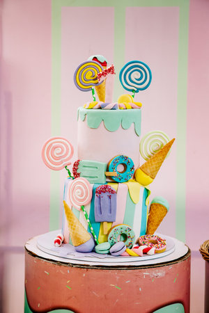 Multi-colored birthday cake for a one-year-old baby girl, decorated with colorful candiesの写真素材