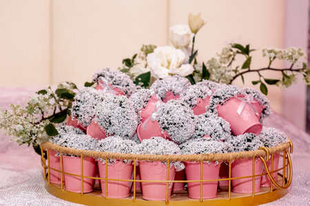 A basket filled with small decorative pink buckets as wedding souvenirs with creative designの写真素材
