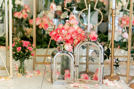 Wedding decorative elements on the floor in restaurant. Natural roses, golden coloured metal and glass elementsの写真素材
