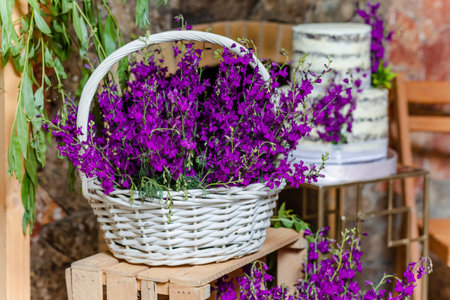 Close up of lavender flowers in basket on wooden box in front of the birthday cake in banquet hallの写真素材