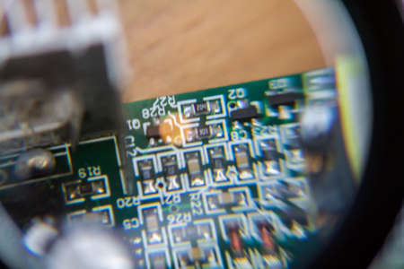 Close-up of the electronic circuit board with a magnifying glass