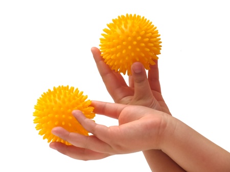 Massage ball in the hand of a little girlの写真素材