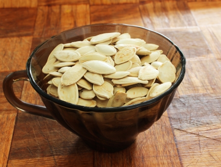 Pile of pumpkin seeds in a cupの写真素材