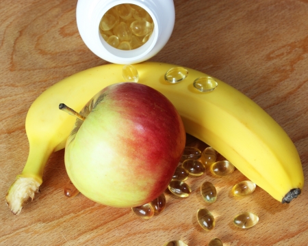 Vitamins in comparison with banana and apple の写真素材