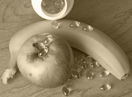 Vitamins in comparison with banana and appleの写真素材