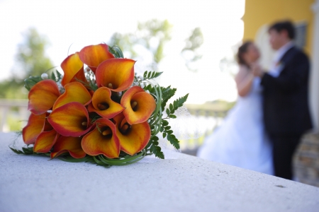 A bouyet in the foregroun with groom and bride in the backgroundの写真素材