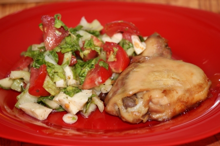 Roasted chicken leg on a red plateの写真素材