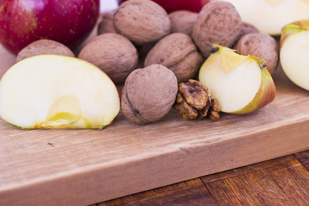 Apple and walnuts on a wooden tableの写真素材