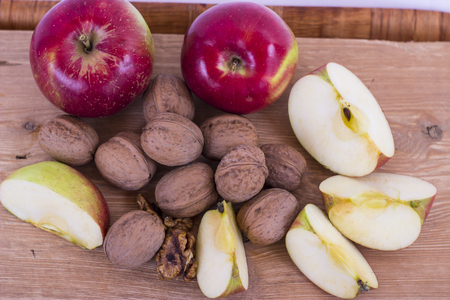 Apple and walnuts on a wooden tableの写真素材