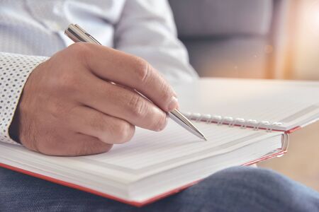 Planning concept. Man writing in a notebook.  Concept for background, website banner, poster, presentation templates, social media, advertising and printed materials.の写真素材