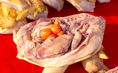 A fresh raw chicken in a marketの写真素材