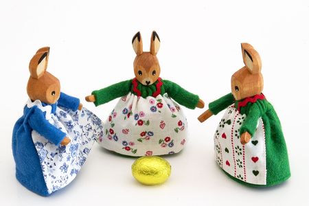 Three wooden easter bunnies with the golden egg