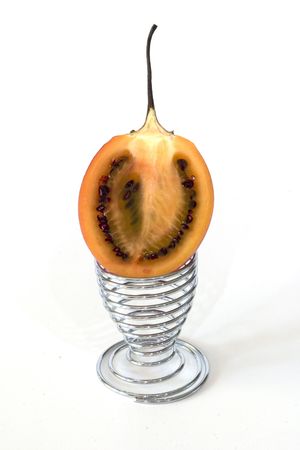 Half a tamarillo sitting in an egg-cupの写真素材