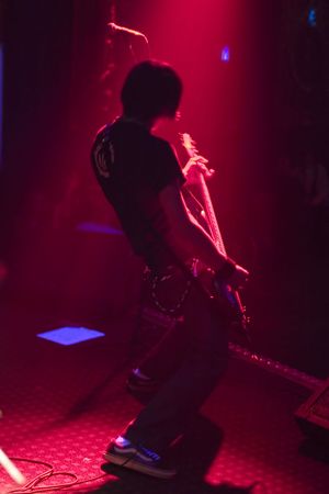 Heavy rock guitar player live on stage bathed in red light