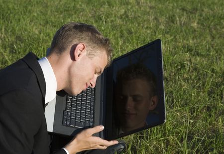 Young business man on in the garden with notebook dreaming sweet dreams, possibly after reading a...
