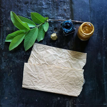 Craft paper background with boho chic style decorations: sketchbook, tree branch, golden paint, ink over black wooden table. Copy space for text. Natural, rustic, ethnic or hipster vintage mock up.の写真素材