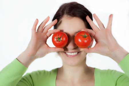 woman holding two tomatoes infront of her eyesの写真素材